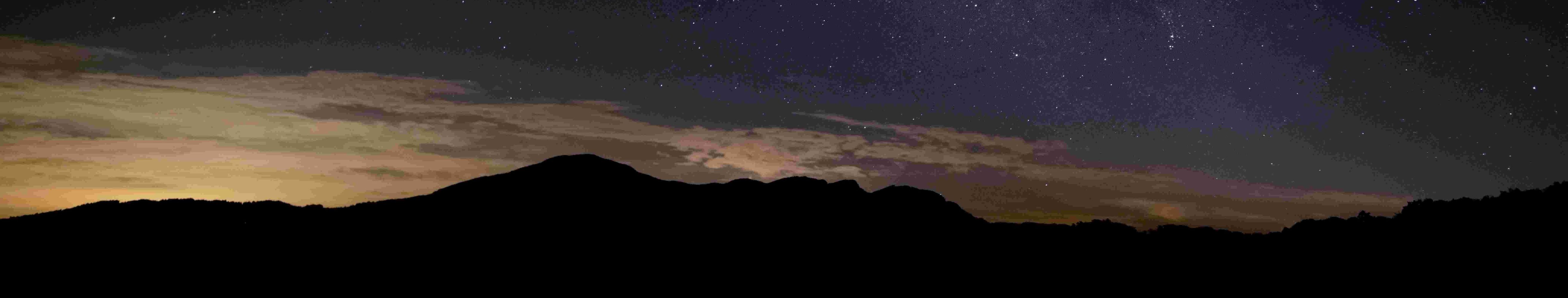 Silhouette of hills under a starry night sky with the Milky Way visible.