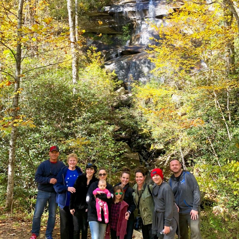 a group of people standing next to a tree