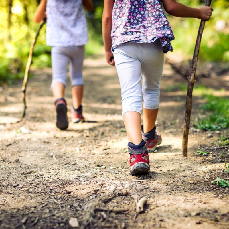 a little girl walking down a dirt road