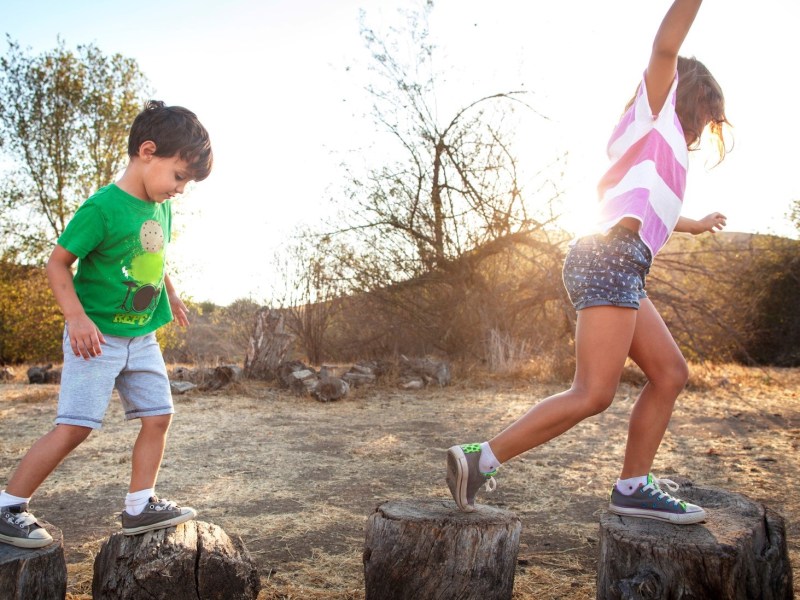 a young boy standing on a rock